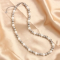 Minimalist stainless steel and pearl beaded necklace displayed on champagne silk fabric - Silver White 8mm