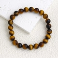 Macro shot of 8mm yellow tiger eye natural stone beads with silk luster on elastic bracelet - Tiger's Eye AB Plus Bracelet