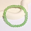 Hellgrünes facettiertes Kristallperlen-Armband auf weißem Keramik-Display - Grün