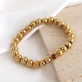Polished 18K gold beaded elastic bracelet with a central red faceted gemstone - 8mm Bead / January (NA22-4 Red)