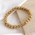 Polished 18K gold-plated beaded elastic bracelet featuring a single sparkling zircon stone - August