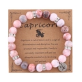 Pink zebra jasper Capricorn zodiac stretch bracelet with silver charms on display card - Capricorn