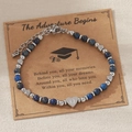 Bracelet perles bleues avec breloque cœur lettre Q et carte de vœux sur fond beige - Lettre Q