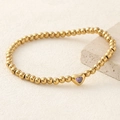 Golden bead bracelet featuring a heart pendant set with a vibrant purple zircon stone - Purple