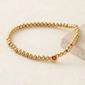 Golden beaded bracelet featuring a red heart-shaped zircon center on a textured base - Red