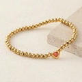 Gold beaded stretch bracelet featuring a vibrant red heart zircon center charm - Orange Red