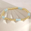 Elastisches Perlenarmband mit polierten Goldperlen und lichtblauen, matten Edelsteinen - Blaue Glas-Zylinderperlen-Stil / Kupferperlen + Glasperlen Armband