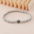 Silbernes Perlenarmband mit Auge des Horus Anhänger auf beigem Hintergrund - Auge des Horus Anhänger (NAD03-4) / 5mm Nicht Verblassender Edelstahl