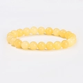 Macro detail of natural translucent yellow crystal beads on a single strand bracelet - Yellow Jade