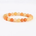 Macro detail of natural stone bead bracelet with polished orange and cream translucent beads - 8mm / Natural Red Aventurine