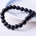 Polished natural black obsidian beaded bracelet for men on a white ceramic plate - Black Crystal