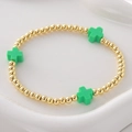 Golden beaded elastic bracelet featuring three vibrant green resin cross charms - Green Cross