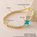 Elastic beaded bracelet featuring 18k gold plated copper beads and cyan clay cross charm - Lake Blue