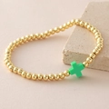 18k gold plated beaded bracelet set with a green cross charm on a stone display - Green