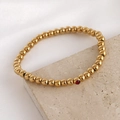 Gold stainless steel beaded bracelet with a single vibrant red zircon gemstone - 5mm / January
