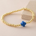 Pulsera elástica de cuentas doradas con un dije de cruz azul mate de estilo moderno - Azul zafiro