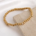 Gold beaded bracelet featuring a single white zircon inlay on polished steel beads - 5mm / April