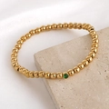 Bracelet élastique à perles dorées minimaliste avec un charme en zircon vert - Mai