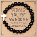 Detail of handmade black beaded bracelet with white cross charm on gift card - Obsidian And Cross