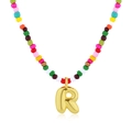 Collana di perline colorate con pendente lettera R dorata su sfondo bianco puro - Lettera R