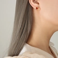 Élégantes boucles d'oreilles vintage dorées avec zircons rouges ovales sur un modèle - Or Zircone Rouge