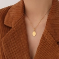 Goldene Good Luck Halskette mit ovalem Anhänger auf brauner Cordjacke präsentiert - 40+5cm / Gold