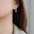 Minimalist silver U-shaped earrings in polished finish worn by a female model - U-Shaped Style / Steel