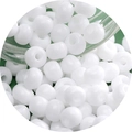 White glass seed beads for DIY jewelry making displayed on a green textured background - Solid White