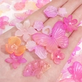 Hand holding pink frosted acrylic butterfly and floral charms for DIY jewelry making - 20g per Pack / Rose Red