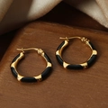 Hoop earrings with gold plating and black enamel blocks on a wooden surface - Black