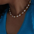 Baroque pearl necklace with gold spacer beads worn by model over dark clothing - Pearl Beaded Style (P1504) / Gold Necklace