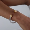 Bracelet torsadé argenté avec embouts dorés sertis de diamants porté au poignet - Style Multicouche / Zircone Jaune