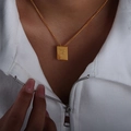 Gold square letter F pendant necklace worn by a model over a white stylish collar top - Letter F Style (P1506-F)