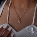 Gold plated Leo zodiac necklace with crystal pavé pendant worn on a model's neck - Leo Style (P1527)