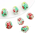 Macro detail of clear glass Christmas beads with 3D tree and gift box for DIY jewelry - Gift Christmas Tree