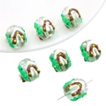 Macro detail of a light green glass Christmas bead with festive hand-painted snow cabin - Snow Cabin Christmas Tree