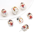 Close-up of snowman and gingerbread house glass beads with holes for DIY jewelry - Snowman