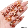 Hand holding 20x17mm amber acrylic butterfly beads with gold edges for DIY jewelry making - 15 Pieces/Pack (1.5mm Hole) / Amber (Butterfly Style)