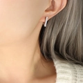 Minimalist silver geometric bar earring with polished finish shown on a female model - Triangle Style (F339) / Steel