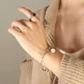 Silver-finish open cuff bracelet with white pearl pendant and square stone ring on model - Silver