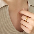Anello minimalista in titanio dorato con inserto tondo in madreperla sulla mano - Perle di Vetro Bianco Oro