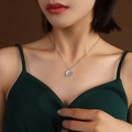 Silver minimalist necklace with rose engraved round pendant worn by model on green outfit - Silver