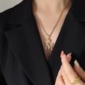 Elegant gold crown initial M pendant necklace with sparkling cubic zirconia on model - Letter M / Gold