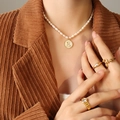 Freshwater pearl necklace featuring a gold-edged letter E shell pendant and gold rings - Letter E