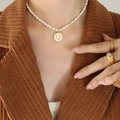 Freshwater pearl necklace with a round golden letter Q pendant shown on a model - Letter Q