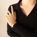 Elegant gold butterfly cuff bracelet and textured ribbed ring set on woman's hand - Gold