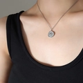 Collier médaille boussole en acier argenté porté par un mannequin sur fond noir - Argent