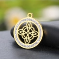 Golden Celtic knot pendant with white zircon inlay on a textured black pebble base - Gold