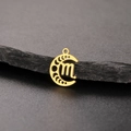 Close-up of golden moon phase pendant with engraved zodiac symbol on dark rock surface - Gold-Scorpio