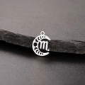 Macro shot of silver moon phase pendant with Scorpio zodiac symbol on dark slate - Silver-Scorpio